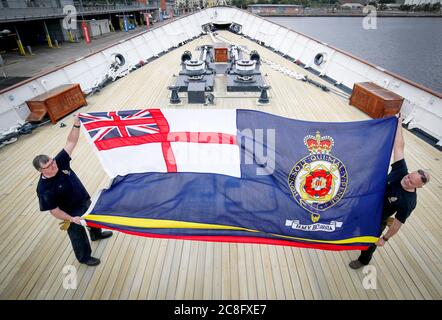 Tony Smith (à gauche) et Rab McAulay, de l'équipe d'entretien, se préparent à lever le drapeau Britannia sur le yacht royal Britannia pour marquer la réouverture de l'attraction touristique d'Édimbourg aux membres du public le lundi 27 juillet. Banque D'Images