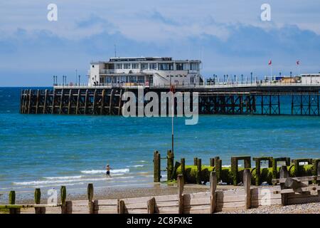 Seafront, Worthing, Royaume-Uni. 24 juillet 2020. Un jeune garçon joue dans la mer en face de Worthing Pier par une journée ensoleillée. Photo par crédit : Julie Edwards/Alamy Live News Banque D'Images