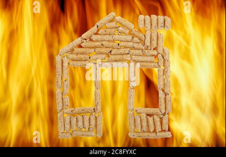 granulés de bois en forme de maison contre les flammes vives Banque D'Images