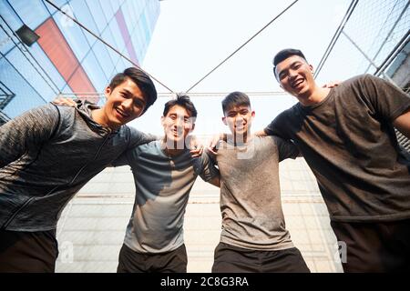 portrait d'une équipe de jeunes athlètes asiatiques regardant vers le bas le sourire de l'appareil photo Banque D'Images