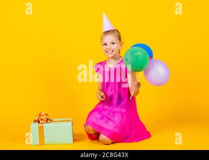 laisse amuse-toi bien. Un enfant heureux joue avec des ballons. Un enfant heureux avec une boîte à présent. Un jour pour les enfants heureux. Le bonheur de l'enfance. Concept de liberté et d'imagination. Drôle de fille ont du plaisir en vacances. Banque D'Images