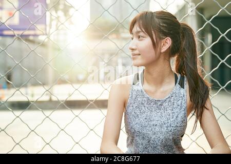 portrait extérieur d'une jeune fille sportive asiatique qui regarde loin sourire Banque D'Images