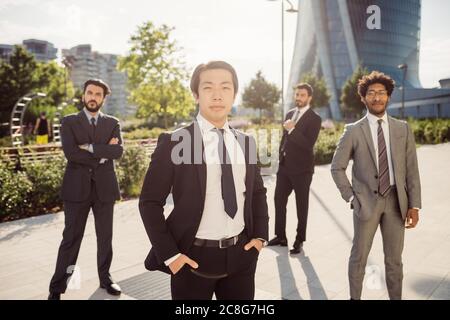 Groupe ethnique mixte d'hommes d'affaires qui traînaient ensemble en ville. Banque D'Images