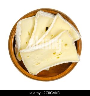 Tranches de fromage à moule mou dans un bol en bois. Fromage crémeux humide, fait de lait de vache, affiné à la surface avec un champignon spécial. Camembert ou Brie. Banque D'Images