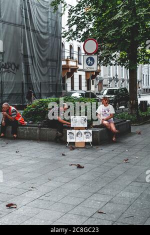 Ukraine, Odessa - 28 août 2019 : un caricaturiste de sexe masculin peint un portrait d'une femme dans la rue du boulevard Primorsky. Banque D'Images