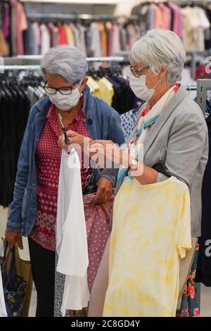 SHEFFIELD 24 JUILLET 2020 : les acheteurs portant un masque de protection parcourent les vêtements dans un magasin de Sheffield. À partir de juillet 24, l'utilisation de la couverture faciale est obligatoire dans les magasins et les supermarchés en Angleterre et pour ceux qui ne portent pas de couverture faciale, la police a le pouvoir de leur facturer une amende de 100 £ pour tenter de freiner la propagation du coronavirus. Credit: Ioannis Alexopoulos/Alay Live News Banque D'Images