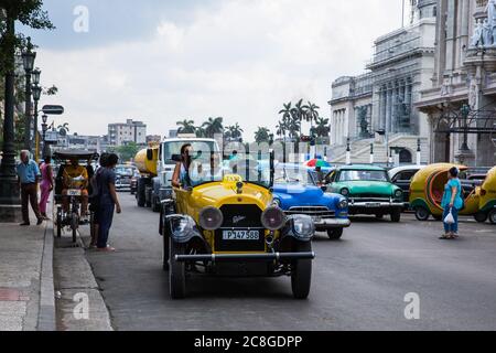 La Havane / Cuba - 04.15.2015: Touristes à bord d'une voiture classique jaune / taxi devant le bâtiment du Capitole Banque D'Images