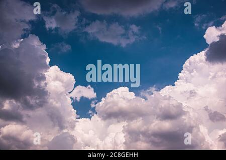 Nuages de pluie massifs, Cumulonimbus nuage duveteux formant dans le ciel bleu Banque D'Images
