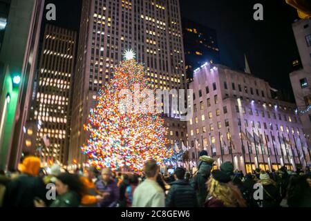 Un grand arbre de Noël se illumine au milieu des bâtiments du Rockefeller Center Banque D'Images