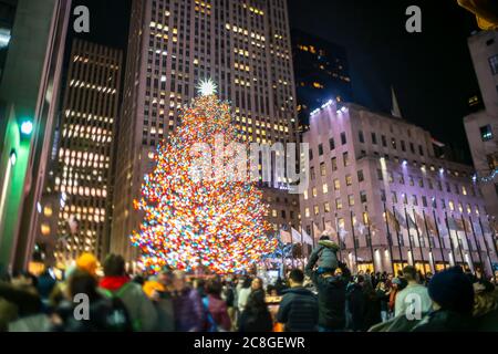 Un grand arbre de Noël se illumine au milieu des bâtiments du Rockefeller Center Banque D'Images