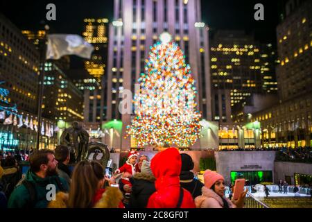 Un grand arbre de Noël se illumine au milieu des bâtiments du Rockefeller Center Banque D'Images