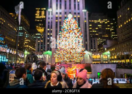 Un grand arbre de Noël se illumine au milieu des bâtiments du Rockefeller Center Banque D'Images