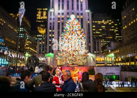 Un grand arbre de Noël se illumine au milieu des bâtiments du Rockefeller Center Banque D'Images