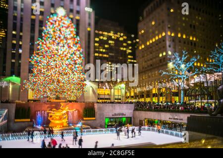 Un grand arbre de Noël se illumine au milieu des bâtiments du Rockefeller Center Banque D'Images