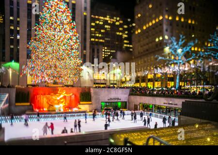 Un grand arbre de Noël se illumine au milieu des bâtiments du Rockefeller Center Banque D'Images