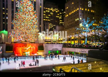 Un grand arbre de Noël se illumine au milieu des bâtiments du Rockefeller Center Banque D'Images