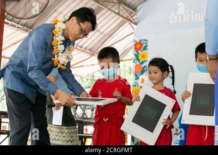 Vientiane, Laos. 23 juillet 2020. Un enfant reçoit un tableau intelligent d'un représentant de l'ambassade chinoise au Laos lors d'une cérémonie de passation de pouvoir à Vientiane, au Laos, le 23 juillet 2020. L'ambassade chinoise au Laos a fait don de 500 tableaux électroniques à des enfants lao dans la maternelle affiliée de l'Université nationale du Laos (NUOL), dans la capitale Vientiane. Crédit: Kaikeo Saiyasane/Xinhua/Alay Live News Banque D'Images