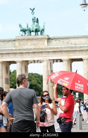 Berlin, Allemagne - vendredi 24 juillet 2020 - les touristes reviennent à Berlin pendant la crise du coronavirus - avec de faibles taux d'infection en ce moment en Allemagne certains voyageurs profitent de la chance de voyager et de visiter les attractions à Berlin certains portant des masques, Certains pas - un groupe de visiteurs écoutent un guide à la porte de Brandebourg, Berlin - photo Steven May / Alamy Live News Banque D'Images