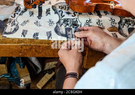 Le violon Carlos Roberts dans son atelier de Cremona Italie changeant le pont de son violon baroque. Banque D'Images