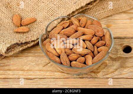 bol d'amandes salées sur une ancienne table en bois Banque D'Images
