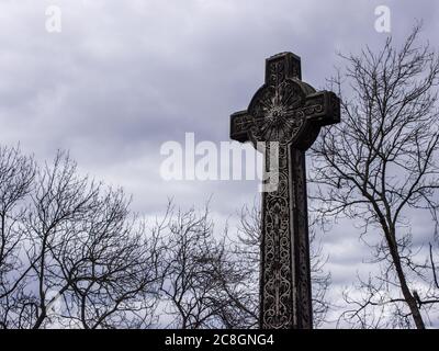 Une croix celtique à côté de l'Esplanade du château d'Édimbourg (Parade Ground) avec des nuages de tempête sombre qui se rassemblent en arrière-plan Banque D'Images