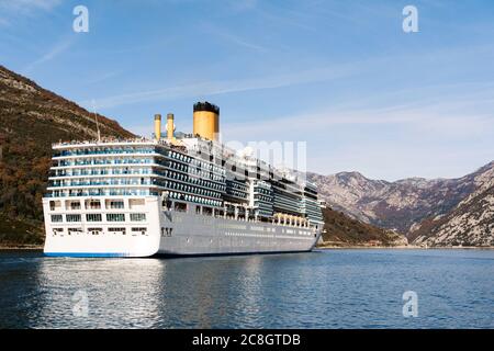 Un grand paquebot de croisière de grande hauteur dans le détroit de Verige, dans la baie de Boka Kottorska - Kotor au Monténégro, sur fond de la ville de Perast. Banque D'Images