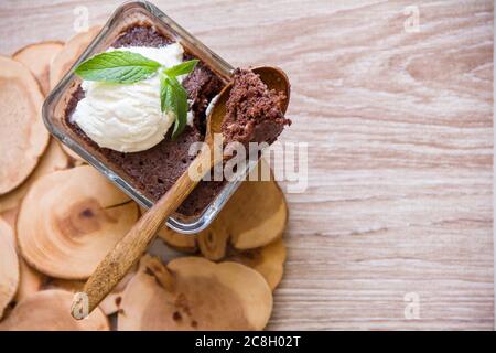Brownie au chocolat dans un plat rectangulaire transparent, servi avec une feuille de menthe et une boule de glace Banque D'Images