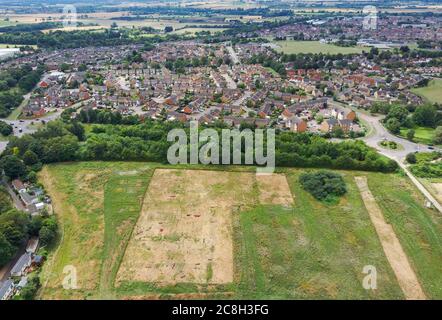 Champ dépouillé pour une excavation archéologique avec empiétement sur le développement de stocks de logements modernes. Biggleswade, Bedfordshire, Royaume-Uni. Banque D'Images