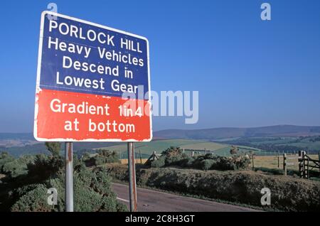 Panneau d'avertissement de la circulation routière à Porlock Hill sur la pente raide A39 indiquant l'utilisation de bas engrenage vallonné terres agricoles paysage Somerset Angleterre Royaume-Uni Banque D'Images