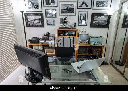 Bureau à domicile avec objets de collection électroniques vintage sur les étagères et encadré de photos noir et blanc sur le mur. L'art mural est le travail des phtographes. Banque D'Images