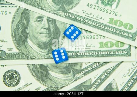 Deux dés bleus sur des billets de cent dollars. Banque D'Images