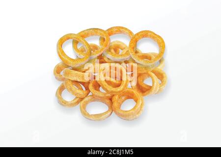 Collation épicée aux anneaux de maïs, aux anneaux d'oignon fryum, pile de grains de maïs croustillants, en-cas à la crème et à l'oignon, mini anneau (Fryums - Frymus) isolé sur fond blanc, SW Banque D'Images