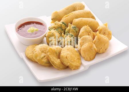 Gota Methi (fenugrec) Pakoda, piment, pomme de terre Pakoda Pakoda (vada) ou beignets indiens la collation, bhajiya, fond blanc, photographi - Image Banque D'Images