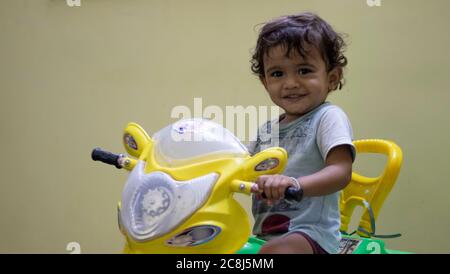 Un petit enfant jouant sa voiture avec un jouet et se sentant heureux, à l'intérieur de la maison Banque D'Images