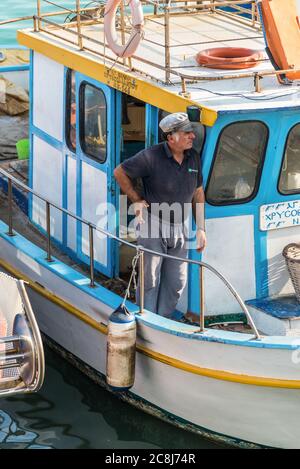 Héraklion, Grèce - 12 novembre 2019 : un bâtard non identifié, debout dans un bateau de pêche en bois, dans le port d'Héraklion, sur l'île de Crète, en Grèce. Banque D'Images