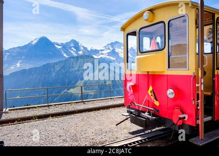 Schynige Platte, Oberland bernois, Suisse - 1 août 2019 : train touristique sur Schynige Platte, par une belle journée d'été, avec le célèbre trio de montagnes GIE Banque D'Images