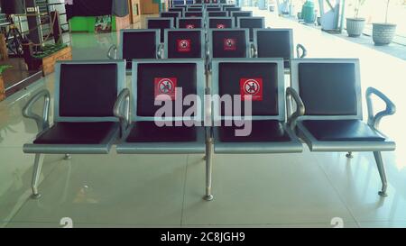 Chaises d'attente à la station qui sont donnés autocollants social distanciation Banque D'Images