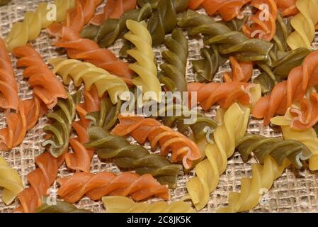 Composition de pâtes crues tricolore fusilli non cuites, forme de torsion des pâtes. Gros plan et attention sélective sur les pâtes fusilli colorées. Pâtes de couleur torsadée Banque D'Images