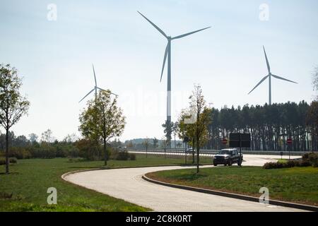 La voiture roule sur la route. Éoliennes en arrière-plan Banque D'Images