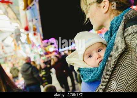 Transport bébé dans une écharpe kangourou par sa mère. Banque D'Images