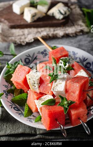 Melon frais avec feta et fromage bleu, recouvert d'herbes Banque D'Images