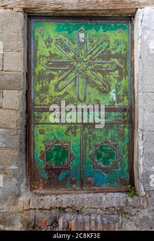 Porte extérieure verte métallique de style arabe endommagée et rouillée Banque D'Images