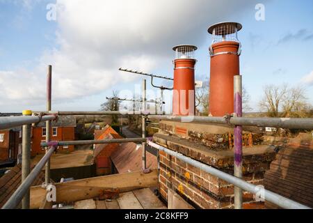 Réparation de cheminées avec échafaudage sur un toit. Travaux de construction sur une rénovation de maison, Royaume-Uni Banque D'Images