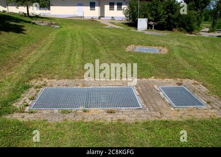 La grille métallique pour pénétrer dans un bassin de rétention d'eau de pluie a été fixée avec un verrou Banque D'Images