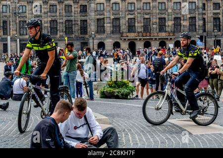 Amsterdam, pays-Bas. 25 juillet 2020. Des policiers qui traversent une rue animée de Kalverstraat.bondés de touristes faisant du shopping dans les rues et le barrage plein de visiteurs avec circulation à sens unique dans Kalverstraat, on essaie de garder un et demi mètres de distance, mais il est difficile au milieu des menaces de coronavirus. Crédit : SOPA Images Limited/Alamy Live News Banque D'Images