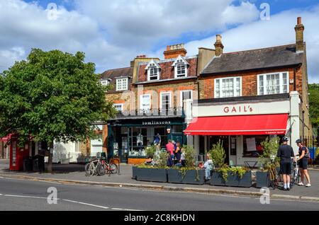 Une boutique et une boulangerie dans le village de Dulwich avec des gens qui profitent du soleil d'été. Dulwich est dans le sud de Londres. Banque D'Images