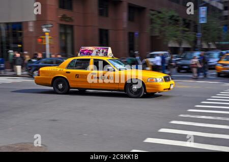 Un taxi jaune New York City en traversant une intersection Dans le centre-ville de Manhattan, un jour d'automne ensoleillé Banque D'Images