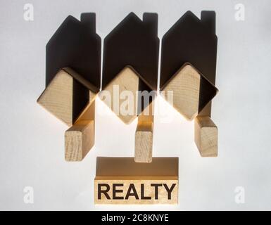 Maisons créées par des ombres à partir de cubes en bois. Le mot « Realty » sur un bloc de bois. Banque D'Images