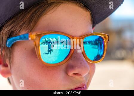 garçon avec des lunettes de soleil regardant le spectacle de cow-boy Banque D'Images