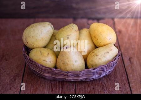 Photo du fruit de la goyave dans un panier sur fond de bois. Banque D'Images